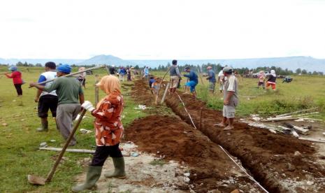 Warga perempuan ikut membuat jalur air dalam program pembuatan fasilitas air minum dan sanitasi.