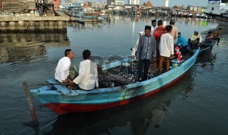   Warga pulang menggunakan perahu sampan usai melaksanakan Shalat Ied di Pelabuhan Sunda Kelapa, Jakarta Utara, Kamis (8/8).  (Republika/Rakhmawaty La'lang)