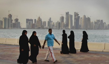 Warga Qatar menikmati berjalan-jalan di pinggir laut di Doha.