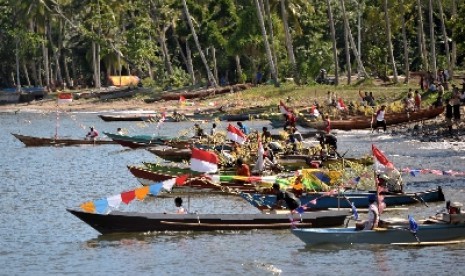 Warga Raja Ampat mengikuti llomba perahu ketinting di Pantai Waisai Tercinta.