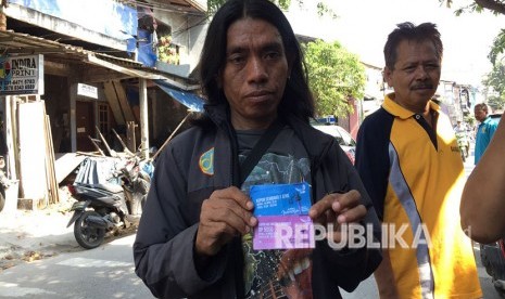 Warga RW 11 Pademangan Barat, menunjukkan kupon maut yang bisa ditukarkan dengan sembako di acara Untukmu Indonesia. 