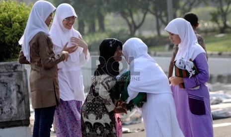  Warga saling memaafkan dan berjabat tangan usai mengikuti Shalat Idul Fitri di pelataran jalan Pasar Senen, Jakarta Pusat, Kamis (8/8).  (Republika/ Yasin Habibi)