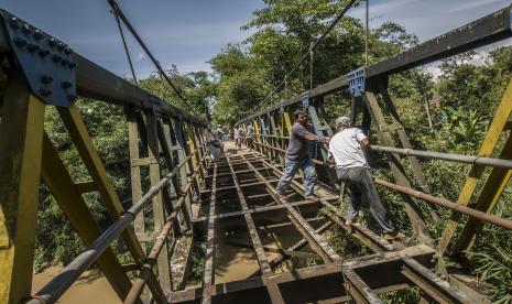 Warga secara swadaya memperbaiki jembatan gantung yang rusak di Rangkasbitung, Lebak, Banten, Rabu (22/12/2021). Jembatan gantung penghubung antardesa yang rusak parah tersebut diperbaiki melalui swadaya masyarakat dengan cara bergotong royong tanpa bantuan pemerintah setempat