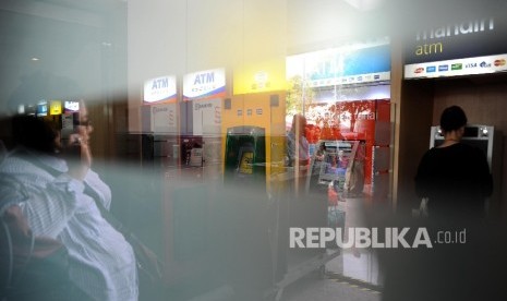 Warga sedang mengunakan Anjungan Tunai Mandiri di ATM Centre, Jakarta