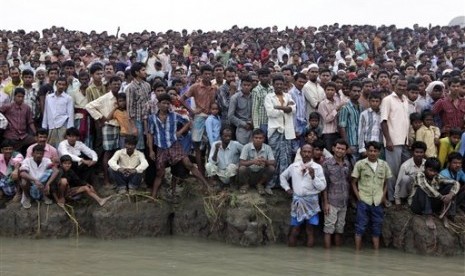 Warga sedang menyaksikan evakuasi korban kapal ferry tenggelam di India.