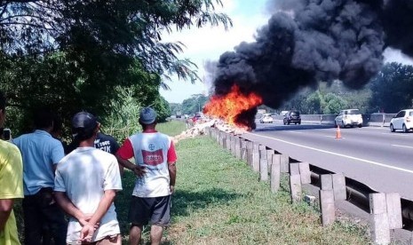 Warga sedang menyaksikan truk boks bermuatan sosis Nopol N 8547 RD, yang terbakar di ruas Tol Cipularang KM 86+400, Kecamatan Jatiluhur, Kabupaten Purwakarta.