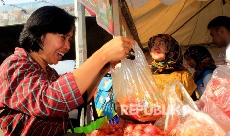 Warga semringah ketika membeli sembako murah di stand Toko Tani Indonesia, di CFD Dago, Kota Bandung, Ahad (15/5). (Foto: Dede Lukman Hakim)