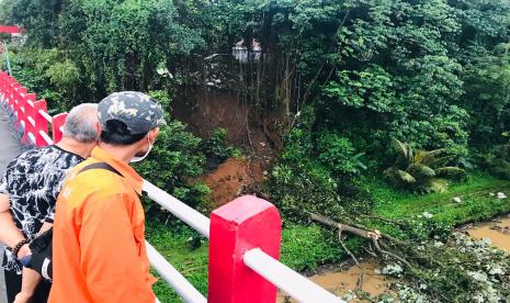 Warga setempat dan anggota BPBD Kota Bogor melihat tanah longsor dan pohon tumbang yang baru saja terjadi di Jalan Paledang, Kecamatan Bogor Tengah, Kota Bogor, Ahad (7/11).