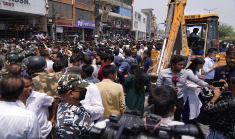 Warga Shaheen Bagh mengepung pejabat selama aksi pembongkaran di New Delhi, Senin, 9 Mei 2022. Pihak berwenang di New Delhi menghentikan aksi pembongkaran di lingkungan yang didominasi Muslim setelah ratusan warga dan sejumlah pekerja partai oposisi berkumpul untuk memprotes Senin . Tidak ada bangunan yang diratakan sebelum buldoser mundur. Ketika Buldoser Jadi Alat Menindas Warga Muslim di India