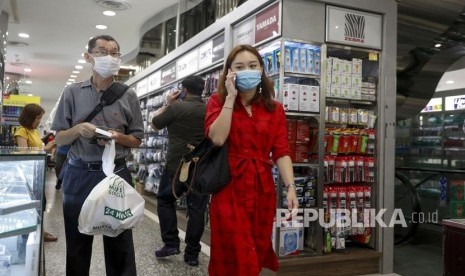 Singapura Selidiki Unggahan Guru Agama Soal Corona. Warga Singapura memakai masker saat berjalan di pusat perbelanjaan di Singapura.