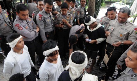 Warga suku asli Baduy menjajakan dagangan khas daerahnya kepada para polisi yang sedang bertugas di kawasan Bundaran Hotel Indonesia (HI), Jakarta, Selasa (6/5).