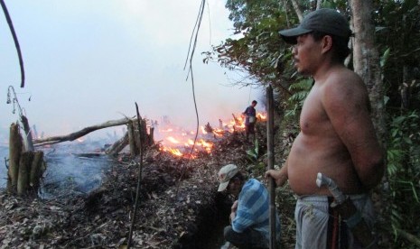 Warga Sungai Utik menjaga batas api berupa selokan kecil saat pembakaran lahan agar api tidak merembet