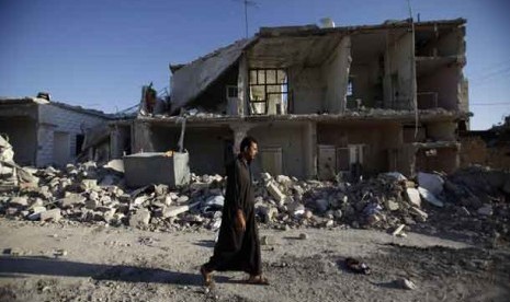 Warga Suriah berjalan melewati gedung yang hancur akibat pemboman dan menewaskan 40 orang di pinggiran kota Aleppo, Suriah, Jumat (24/8).