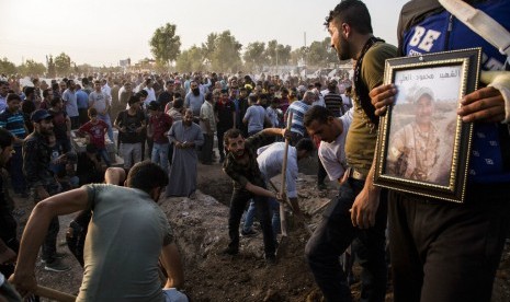 Warga Suriah mengubur jenazah anggota Tentara Demokratik Suriah (SDF) yang memerangi Turki di Kota Qamishli, Suriah, Sabtu (12/10).