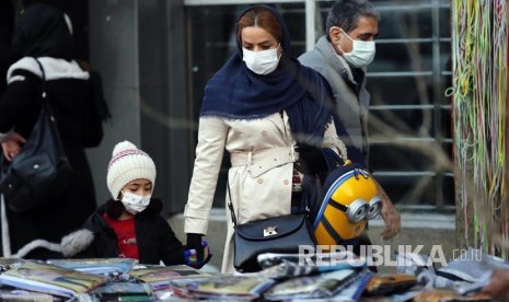 Warga Teheran Iran melintasi jalanan kota menggunakan masker, Sabtu (22/2). Iran melaporkan 709 orang meninggal dunia akibat virus corona, angka kematian harian Covid-19 tertinggi di negara Timur Tengah yang mengalami wabah kelima, dipicu varian Delta yang sangat menular.