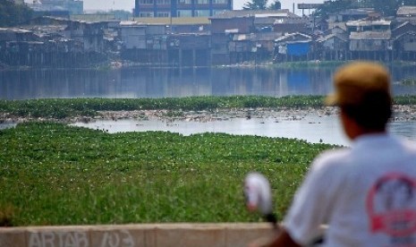 Warga tengah duduk santai menatap waduk pluit. 