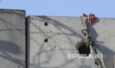 Warga Tepi Barat Palestina menaiki tangga untuk menlintasi tembok pemisah yang dipasang Israel untuk shalat jumat di Kompleks Al Aqsa, Jumat (8/6). Konflik Israel-Palestina menjadi salah satu agenda yang harus diselesaikan Indonesia sebagai anggota DK PBB.