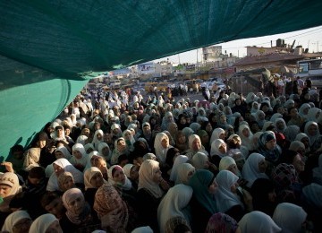 Warga Tepi Barat, Palestina, menunggu untuk melewati pos penyeberangan Qalandia dalam perjalanan menuju Masjid Al Aqsa untuk beribadah.