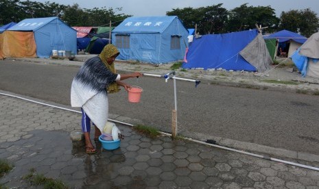 Warga terdampak gempa mencuci peralatan dapur di Kamp Pengungsian Sementara di halaman Masjid Agung Darussalam Palu, Sulawesi Tengah, Kamis (8/11/2018). 