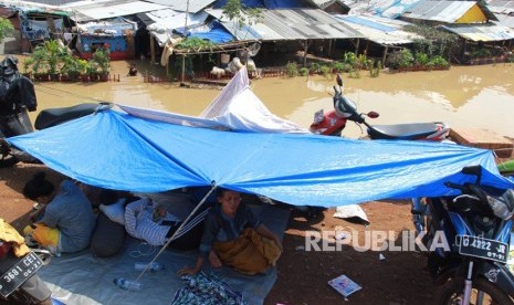 Warga terpaksa mengungsi ke dataran yang lebih tinggi karena rumahnya terendam banjir akibat meluapnya sungai Cisadane di kawasan Karawaci, Tangerang, Banten, Jumat (26/4/2019).