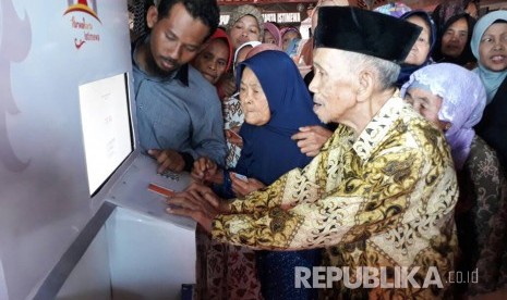 Warga tidak mampu asal Desa Wanakerta, Kecamatan Bungursari, Kabupaten Purwakarta, sedang mencoba ATM beras perelek, Kamis (1/6). Bertepatan dengan momen peringatan Hari Lahir Pancasila, Pemkab Purwakarta meluncurkan fasilitas ATM beras untuk membantu warga. 