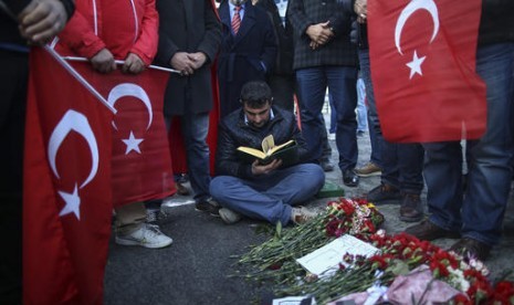 Warga Turki berkumpul membaca doa dan meletakkan bunga sebagai penghormatan terhadap korban dua bom di luar stadion Besiktas di Istanbul, Ahad, 11 Desember 2016.