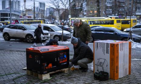 Warga Ukraina membongkar generator listrik sebelum memasangnya di cabang bank di Kyiv, Ukraina, pada 1 Desember 2022. Kazakhstan menyumbang 41 generator untuk digunakan di rumah sakit Ukraina, seperti diumumkan Kementerian Kesehatan negara yang dilanda perang tersebut.