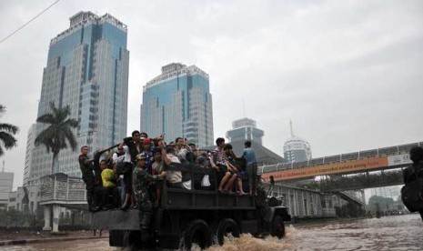 Warga yang bekerja di kawasan Sudirman terpaksa harus di evakuasi menggunakan truk untuk melintasi air banjir yang menggenangi kawasan Jalan Sudirman,Jakarta Pusat, Kamis (17/1).