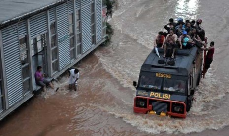 Warga yang bekerja di kawasan Sudirman terpaksa harus di evakuasi menggunakan mobil Rantis untuk melintasi air banjir yang menggenangi kawasan Jalan Sudirman,Jakarta Pusat, Kamis (17/1).