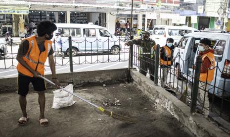 Warga yang melanggar aturan protokol kesehatan COVID-19 menyapu sampah saat terjaring Operasi Tertib Masker di kawasan Kampung Melayu, Jakarta, Senin (7/9/2020). Satpol PP DKI Jakarta mencatat jumlah denda akumulasi pelanggaran ketentuan Pembatasan Sosial Berskala Besar atau PSBB transisi mulai 22 Mei hingga 31 Agustus 2020 mencapai Rp4 miliar dengan denda perorangan pelanggar penggunaan masker menjadi yang paling besar yaitu sebanyak Rp1,94 miliar.