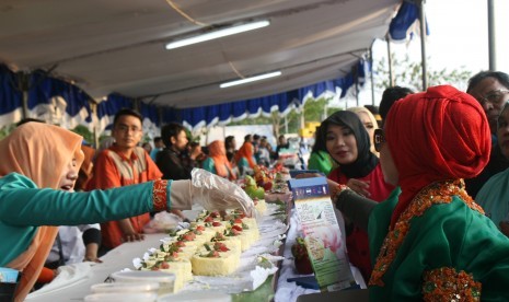 Warga yang mendatangai anjungan Pantai Losari, Makassar, mencoba berbagai panganan dari pisang ijo.