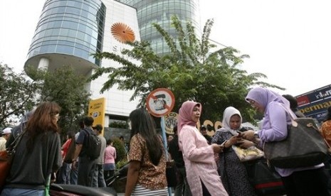 Warga yang tengah berbelanja tampak berkerumun usai dievakuasi dari sebuah mal di Medan, Sumut, Rabu (11/4).