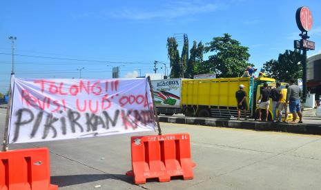 Warga yang tergabung dalam Seguyub Rukun Sopir Indonesia (SRSI) membagikan brosur kepada sopir di jalan pantura, Jati, Kudus, Jawa Tengah, Rabu (9/3/2022). Aksi tersebut sebagai pemberitahuan rencana aksi mogok kerja sekaligus unjuk rasa seluruh sopir truk logistik di wilayah Jawa Tengah untuk merevisi kebijakan pemerintah terkait pembatasan dan pelarangan truk Over Dimension Over Loading (ODOL) atau kelebihan dimensi dan muatan di kantor gubernur Jawa Tengah pada 11 maret 2022