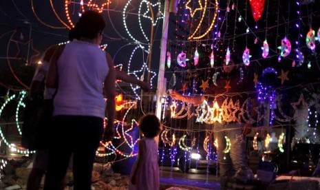 Warga Yordania melihat dekorasi hiasan lampu untuk Ramadhan di Amman, Yordania, Kamis (19/7). (Mohammad Hannon/AP)