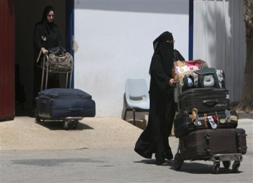 Warga Palestina melintas di pintu perbatasan Rafah yang menghubungkan Mesir dengan Gaza.