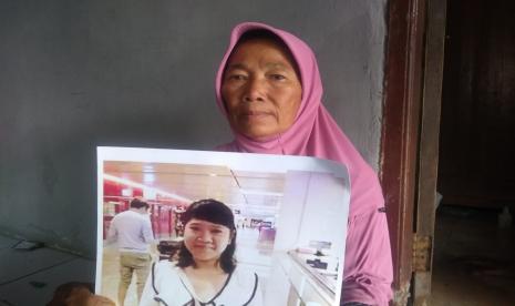 Warpen (60), warga Blok Balai Desa, Desa Cempeh, Kecamatan Lelea, Kabupaten Indramayu, menunjukkan foto anaknya, Siti Faridah, Ahad (9/10/2022). Siti Faridah hilang kontak selama sembilan tahun di Singapura. 