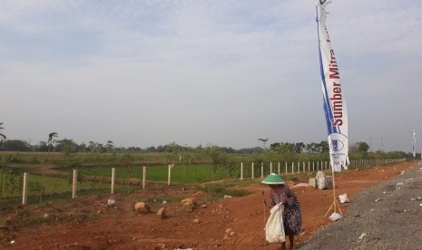 Warsinah, warga Pemalang, memunguti sampah botol di ruas tol Pemalang Batang. 