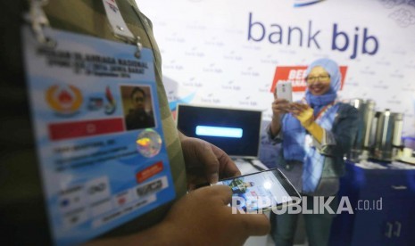 Wartawan peliput PON XIX 2016 Jabar berfoto selfie di stan relaksasi Bank BJB, di Media Centre Utama (MCU), Trans Hotel Bandung, Kota Bandung, Ahad (18/9). (Republika/Edi Yusuf)