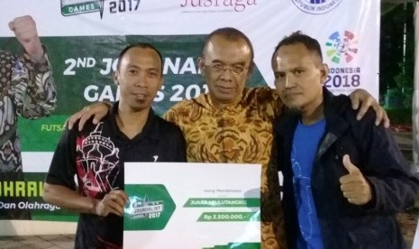 Wartawan Republika Fitriyanto (kanan) berfoto bersama Sesmenpora Gatot S Dewa Broto saat penyerahan hadiah juara bulu tangkis 2nd Journalist Games 2017 di Kantor Kemenpora, Jakarta, Sabtu (9/12). Fitriyanto menjuarai ganda putra bulu tangkis berpasangan dengan jurnalis Berita Satu, Iman Rahman Cahyadi.