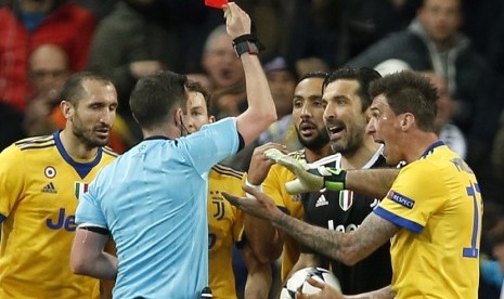 Wasit asal Inggris Michael Oliver memberikan kartu merah kepada kiper Juventus Gianluigi Buffin dalam perempat final leg kedua Liga Champions antara Real Madrid menghadapi Juventus di Santiago Bernabeu, Kamis (12/4) dini hari WIB. 