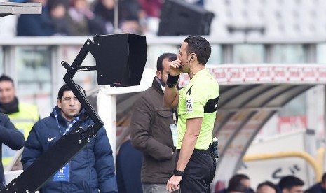 Wasit berkonsultasi dengan sistem asisten wasit (VAR).