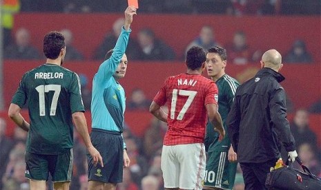 Wasit Cuneyt Cakir saat mengusir Nani di leg kedua 16 besar Liga Champions, Rabu (6/3) lalu.