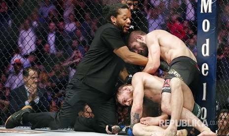 Wasit  Herb Dean mendorong Khabib Nurmagomedov setelah  McGregor melakukan 'tap out' sebagai tanda menyerah pada laga UFC 229 di Las Vegas, Sabtu (8/10) waktu setempat.