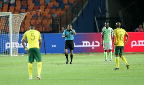 Wasit Jiyed Redouane mensahkan gol timnas Afrika Selatan setelah mendapat review hasil VAR dalam laga perempat final Piala Afrika 2019 antara Nigeria lawan Afrika Selatan di Kairo, Mesir, Rabu (10/7).