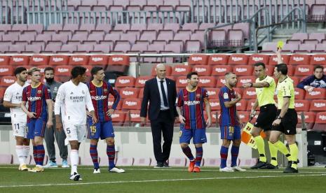 Wasit Juan Martinez Munuera (kanan) memberikan kartu kuning kepada pemain Barcelona Jordi Alba dalam laga El Clasico kontra Real Madrid, Sabtu (24/10). Juan Martinez mendapatkan kritikan dari pihak Barcelona atas kepemimpinannya dan harian Sport melaporkan, ayahnya merupakan pendiri fan klub Real Madrid.