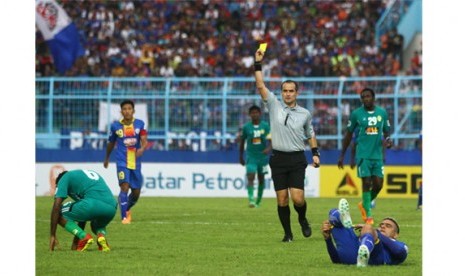 Wasit Kurbanov Charymurat (tengah) memberi hukuman kartu kuning kepada pesepakbola Maziya S&R-Maladewa , Abdulla Ibrahim (kiri) usai melakukan pelanggaran terhadap pesepakbola Arema Indonesia Cronus, Cristian Gonzales (kanan) dalam pertandingan AFC Cup di 