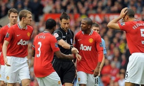 Wasit Mark Clattenburg (tengah) dikerubungi pemain Manchester United yang memprotes keputusan kartu merah Jonny Evans. (ilustrasi)