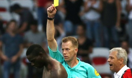 Wasit memberikan kartu kuning kedua kepada striker Nice, Mario Balotelli (kiri) pada laga Ligue 1 lawan Lorient, Ahad (2/10). Laga di stadion Allianz Riviera itu berakhir kemenangan untuk Nice, 2-1.