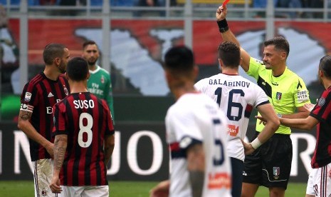 Wasit Piero Giacomelli (kedua dari kanan) memberikan kartu merah kepada kapten AC Milan Leonardo Bonucci (kiri) pada laga Rossoneri kontra Genoa di Stadion San Siro, Ahad (22/10). 