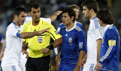 Wasit Ravshan Irmatov (kedua kiri) saat memimpin laga Piala Dunia 2010.